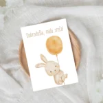 čestitka ob rojstvu zajček z balonom in napisom "dobrodošla, mala sreča!"